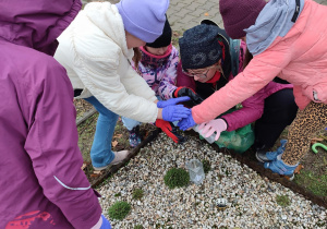 Uczniowie wraz z wychowawczynią zapalają znicz.