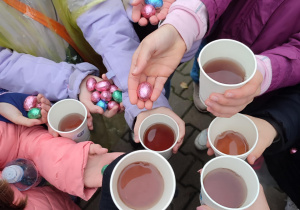 Uczniowie rozgrzewają się ciepłą herbatką.