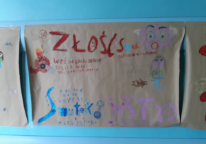 Plakat wykonany przez uczniów przedstawiający emocje: złość, strach, smutek, wstyd.